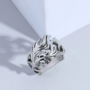 Gothic dragon ring with vintage silver flame patterns on a minimalist stone background