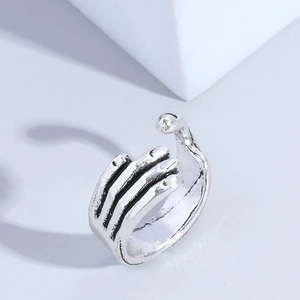 Vintage skull hand open ring in punk style with distressed silver finish on grey background