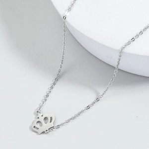 Minimalist silver crown pendant necklace with fine chain on geometric stand