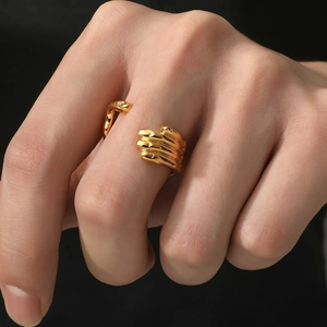 Detailed close-up of a gold skeleton hand hug ring with adjustable open design on a hand