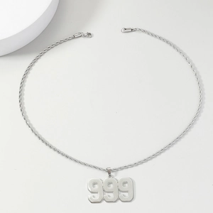 Detailed shot of hip-hop number 999 pendant with a thick rope chain on a clean surface