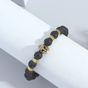 Detailed macro of black lava beads and vintage gold Spartan helmet charm on the bracelet