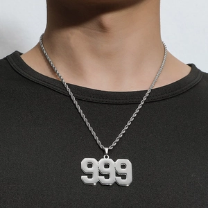 Close-up of a silver rope chain necklace with a hollow number 999 pendant on a model