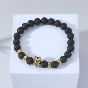 Detailed macro view of black volcanic lava beads and golden spartan helmet charm bracelet