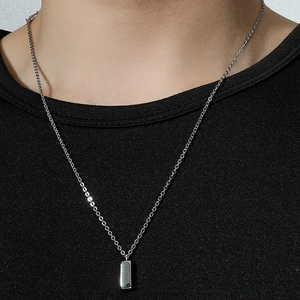 Collier minimaliste en acier titane avec pendentif barre sur tricot noir chic