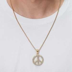 Close-up of hip-hop peace sign pendant necklace with pavé crystals on gold-plated chain