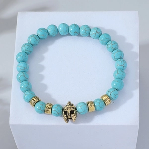 Turquoise bead bracelet featuring a golden Spartan helmet charm and engraved spacers