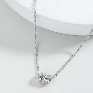 Silver cylinder pendant necklace with roman numerals and crystals on cross chain