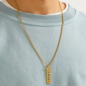 Macro shot of gold stainless steel military tag pendant with moon phase cutout on box chain