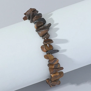 Detailed view of polished irregular tiger eye stone beads on a woven minimalist bracelet