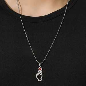 Minimalist silver bead chain necklace with hollow heart-gesture pendant and red accent