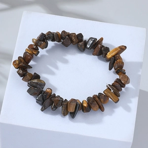 Detail of natural tiger eye stone bracelet with irregular polished beads on a white base