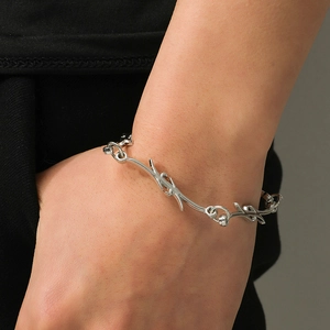 Macro shot of silver thorn-shaped link chain bracelet worn on wrist for punk style