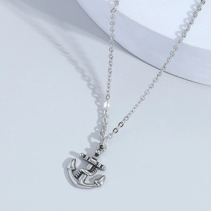 Vintage silver punk anchor necklace with distressed finish on white pedestal stand