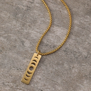 Detailed close-up of golden stainless steel sun and moon phase hollow pendant on chain