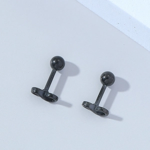 Detailed view of matte black infinity symbol barbell stud earrings on a grey surface