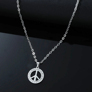 Vue macro d'un pendentif symbole de paix en acier inoxydable avec strass scintillants