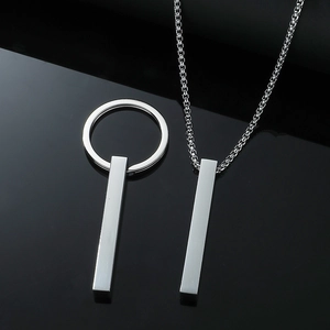 Collier avec pendentif hip-hop minimaliste argenté et chaîne box sur surface noire