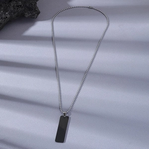 Collier à pendentif rectangulaire noir avec chaîne à boules argentée sur fond violet