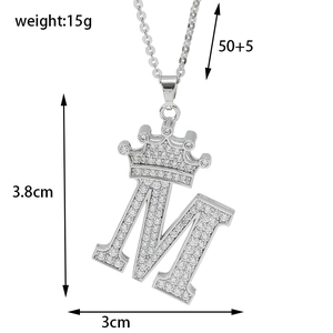Detail view of M letter pendant with crown and pavé zircon stones on cross chain