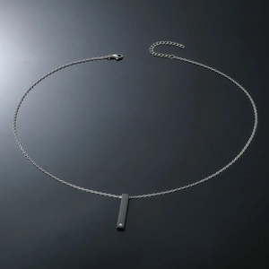 Detailed view of square bar pendant necklace with inset cubic zirconia on matte steel