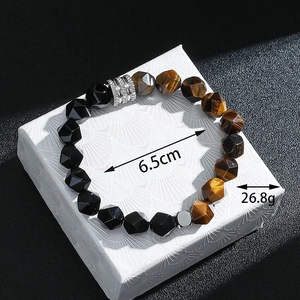 Détail du bracelet en perles d'œil de tigre et obsidienne sur une boîte cadeau blanche