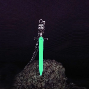 Luminous sword pendant with wolf head design glowing green light on dark stone base