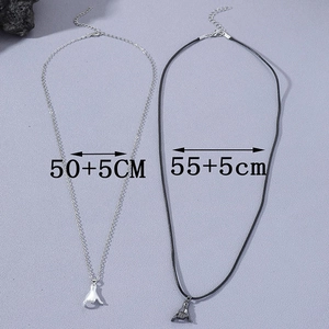 Couples minimalist pendant necklaces with Shaka hand gesture on grey textured background