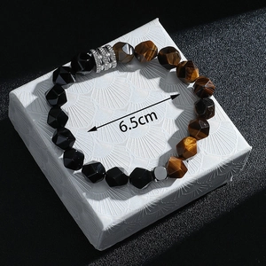Détail d'un bracelet en œil de tigre de 6,5 cm posé sur un coffret à bijoux
