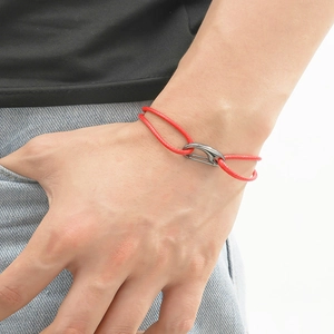 Gros plan sur un bracelet tressé rouge avec fermoir en crochet en U gris métal