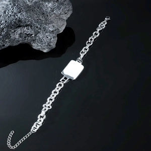 Mens silver cuban link chain bracelet with a polished rectangular bar on dark background