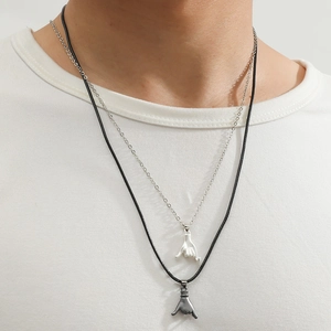Double layered couple necklace set with hand gesture pendants on white t-shirt