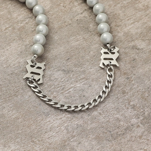 Collier de perles et chaîne gourmette argentée avec lettres M gothiques sur pierre