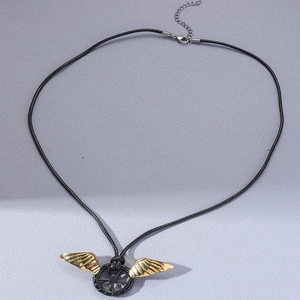 Detailansicht der goldenen Flügel-Anhänger mit schwarzem Rad an geflochtener Halskette
