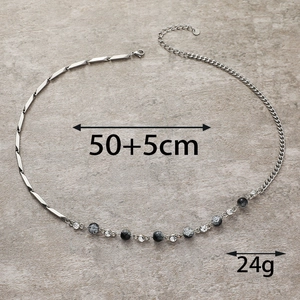 Dettaglio della collana asimmetrica in acciaio al titanio con perline effetto ghiaccio