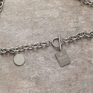 Close-up of stainless steel chain necklace with OT buckle and heart engraving