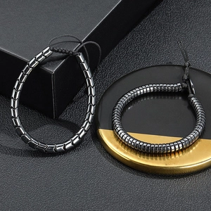 Men's black hematite beaded bracelet set with adjustable woven cord on leather background