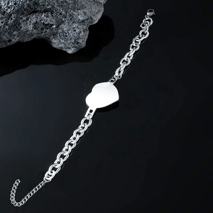 Silver stainless steel chain bracelet with a heart tag on a black stone background