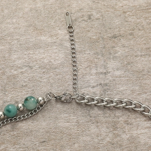 Macro shot of silver titanium chain with agate beads and a lobster clasp detail