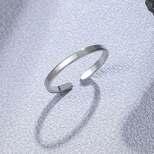 Polished minimalist silver titanium steel open adjustable ring on a textured background