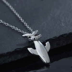 Pendentif queue de baleine minimaliste en acier argenté poli sur pierre d'ardoise