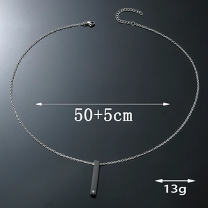 Detailed view of black bar pendant with cubic zirconia and silver-tone chain necklace