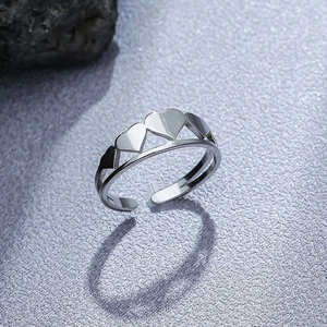 Macro shot of silver adjustable hollow heart ring on minimalist purple backdrop