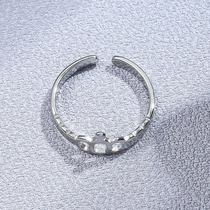 Bague couronne argentée ajourée avec texture géométrique sur fond nacré violet