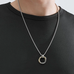 Close-up of men's interlocking triple ring pendant necklace on a black T-shirt