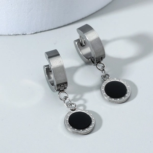 Macro detail of vintage geometric square earrings with brushed silver finish and black inlay