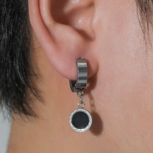 Minimalist silver hoop earrings with a black circular pendant and beaded edge texture