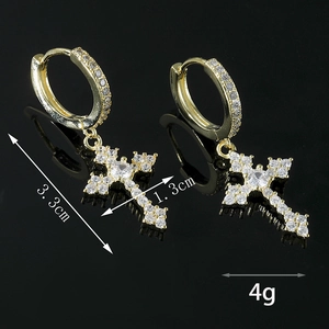 Détail des boucles d'oreilles croix dorées avec zircons sertis, dimensions 3,3 cm par 1,3 cm