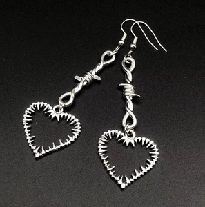 Vue détaillée de boucles d'oreilles cœur épines argentées au style punk gothique ténébreux