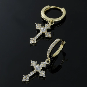 Boucles d'oreilles croix dorées avec zircons blancs et poinçon S925 sur fond noir